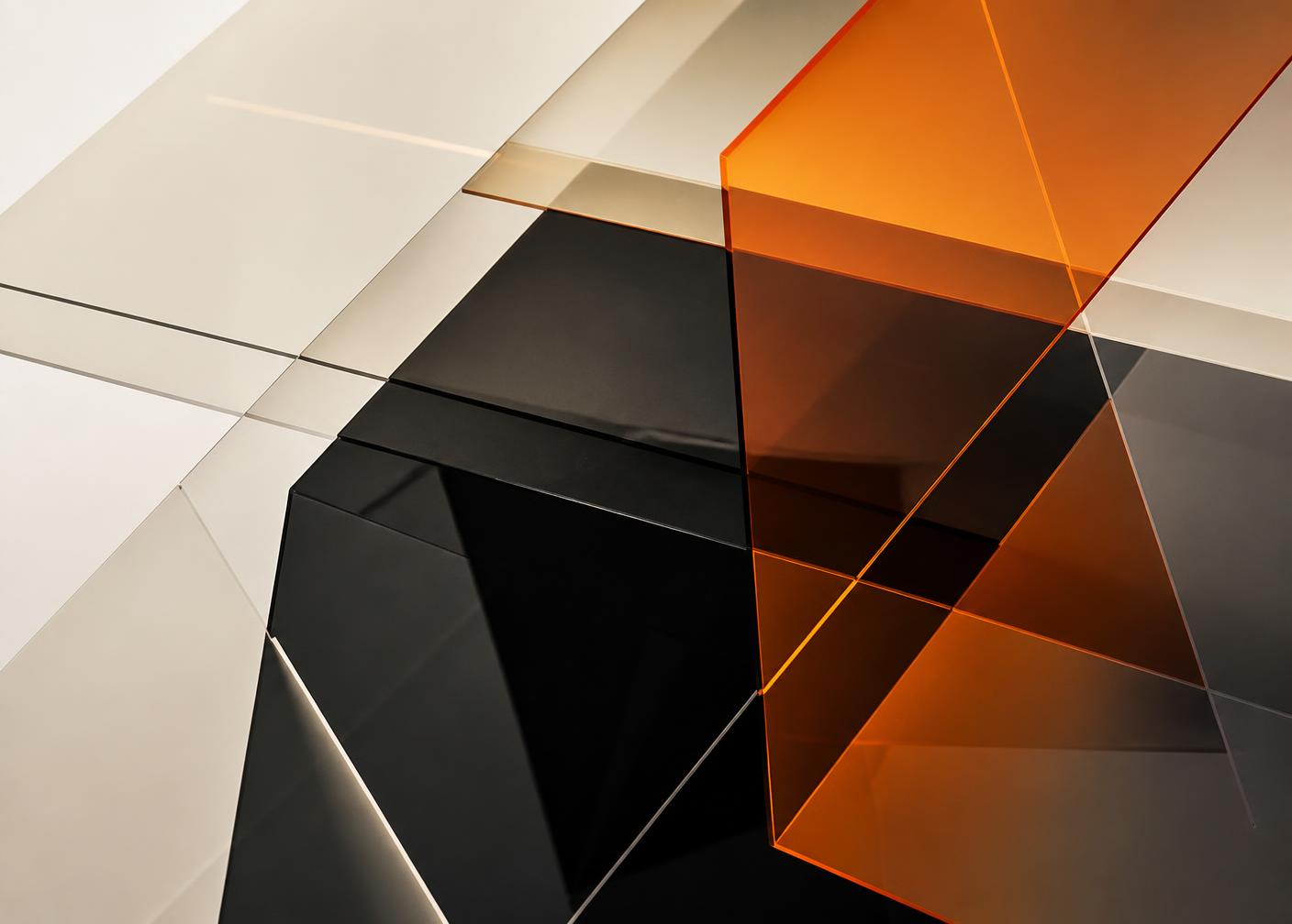 Layered translucent geometric panels in amber, cream and black suggesting structured system layers